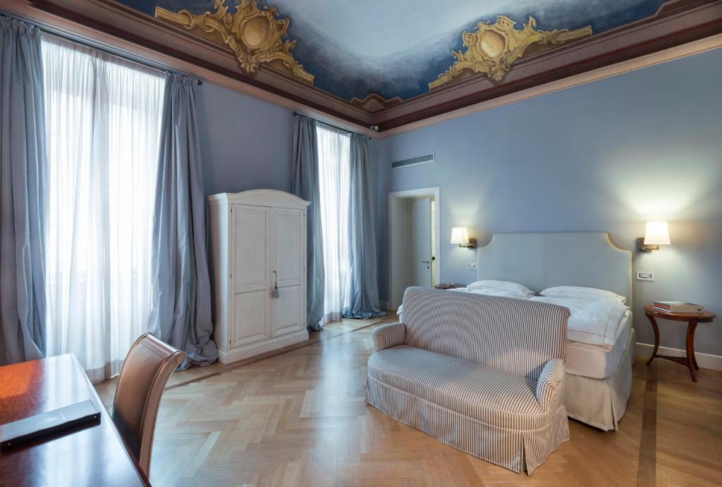 um quarto com uma cama, um sofá e uma mesa em Grand Hotel Della Posta em Sondrio