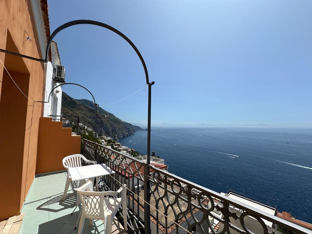 a balcony with two chairs and a view of the ocean at Praiano Amalfi Coast Casa con Vista Mare in Praiano