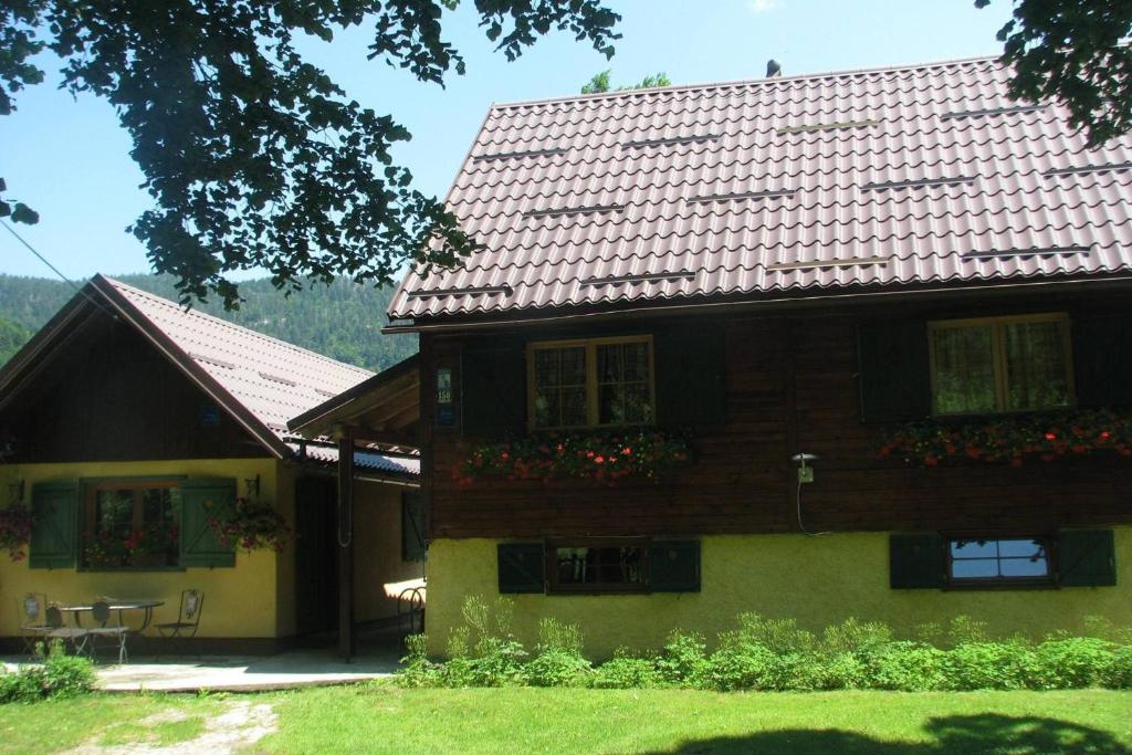 a wooden house with flowers in front of it at Apartments with swimming pool Jasenak, Karlovac - 20718 in Jasenak