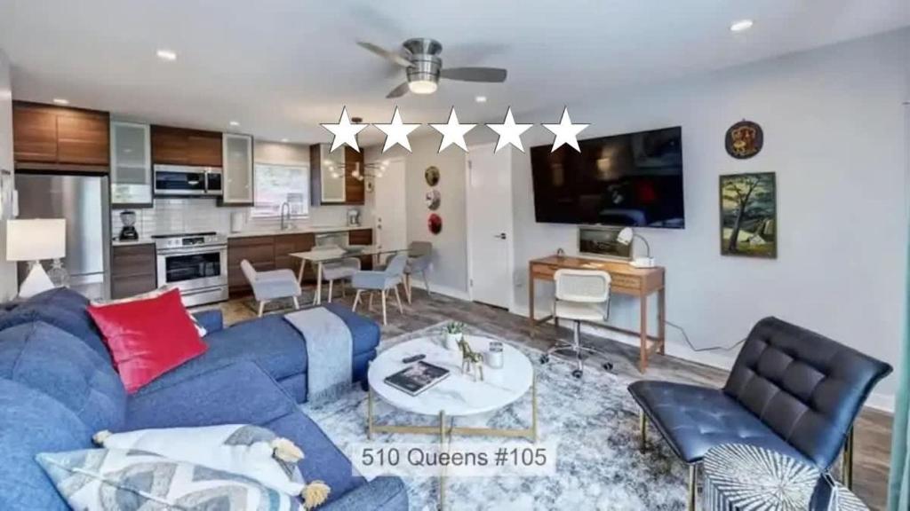 a living room with a blue couch and a kitchen at Experience Myers Park in Style in Charlotte