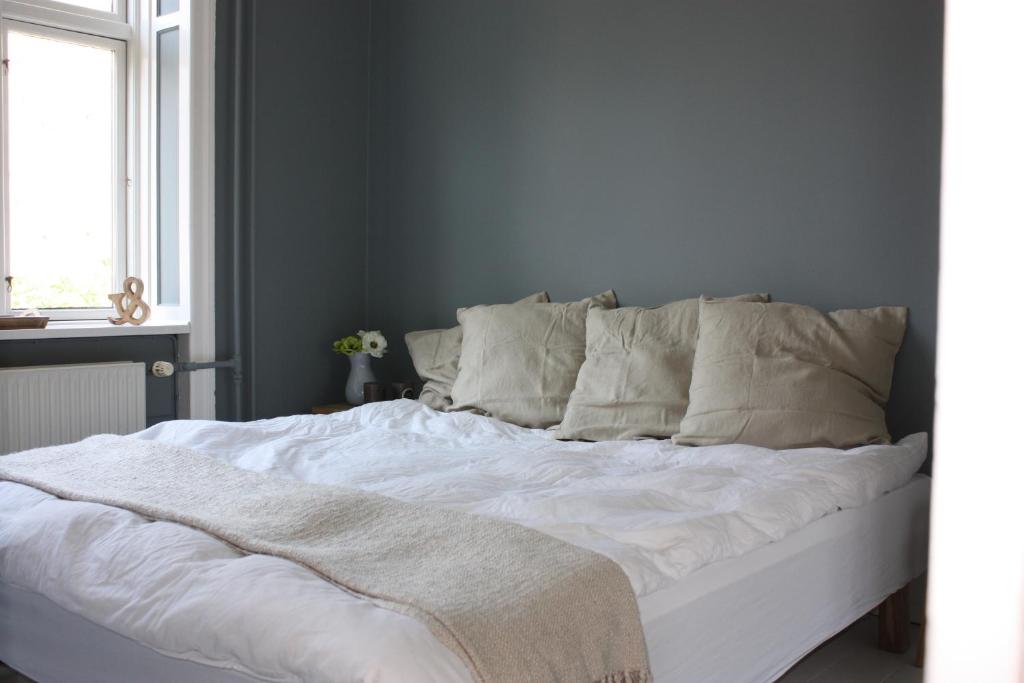 a bed with white sheets and pillows in a bedroom at Home sweet home CPH in Copenhagen