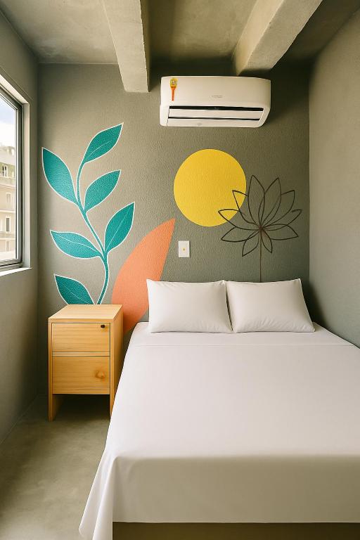 a bedroom with a bed and a wall with flowers at Joy Hostel & Suítes in Brasilia
