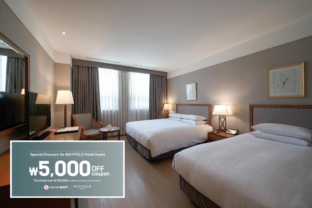 a hotel room with two beds and a flat screen tv at Mayfield Hotel Seoul in Seoul