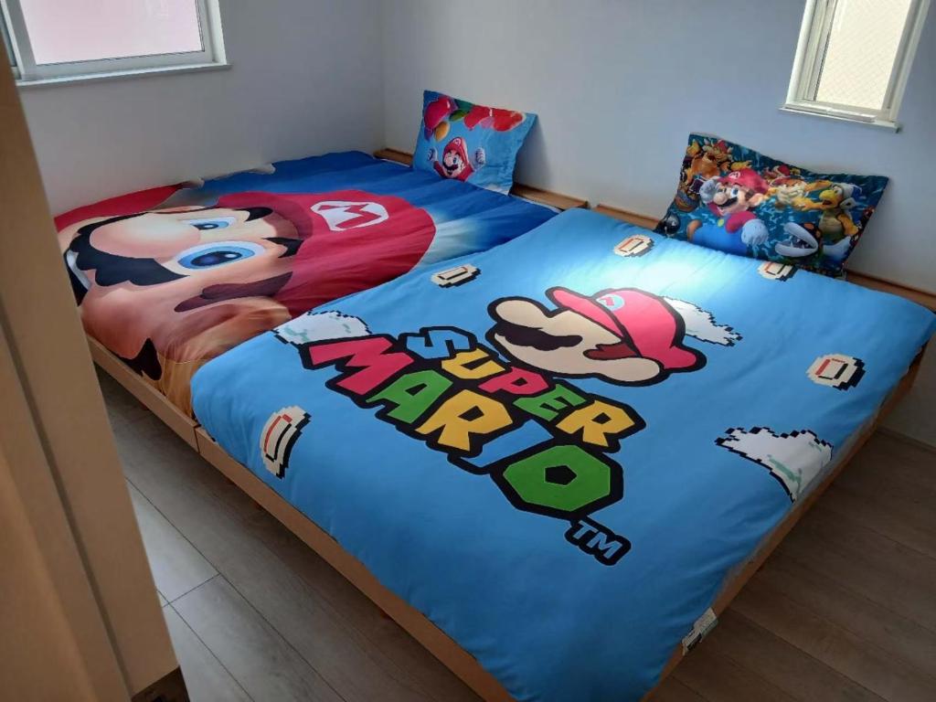 a bed with a blue comforter with a cartoon on it at 花喜Usj in Osaka