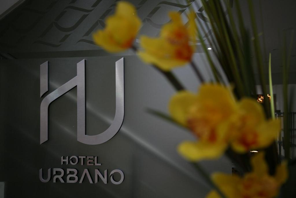una señal para un hotel umaru con flores amarillas en Hotel Urbano en La Banda