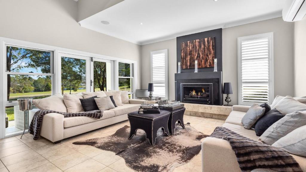 a living room with two couches and a fireplace at The Vintage Manor in Pokolbin