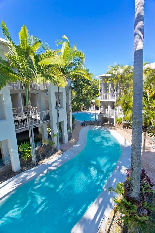 an aerial view of a resort swimming pool with palm trees at Offshore Noosa Resort in Noosaville