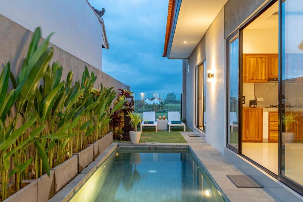 a swimming pool in the backyard of a house at Villa Uma Tegal Cemagi in Cemagi