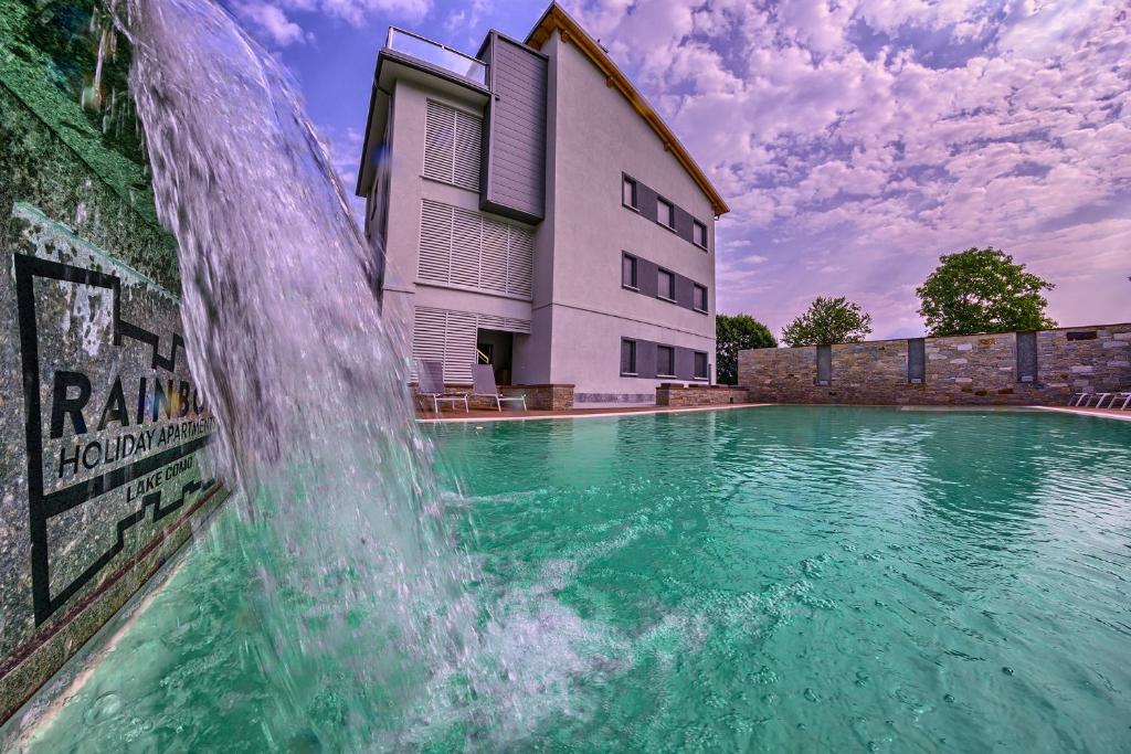 a water fountain in front of a building at Rainbow Holiday Apartments Lake Como in Colico