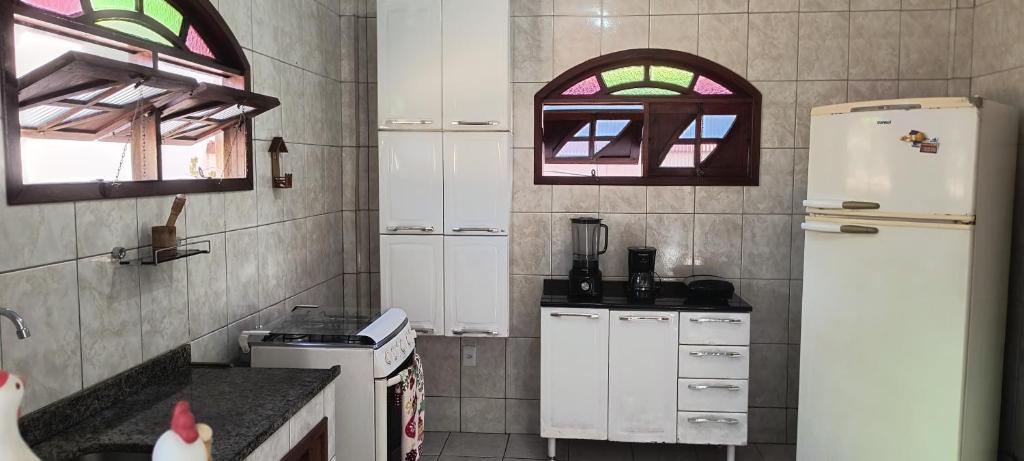 a kitchen with a white refrigerator and a window at CasaPraiaSol1 in Rio das Ostras