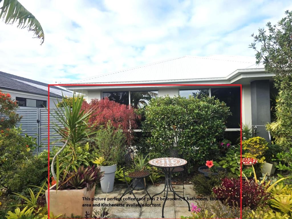 a garden in front of a house with plants at Marina Views in Banksia Beach