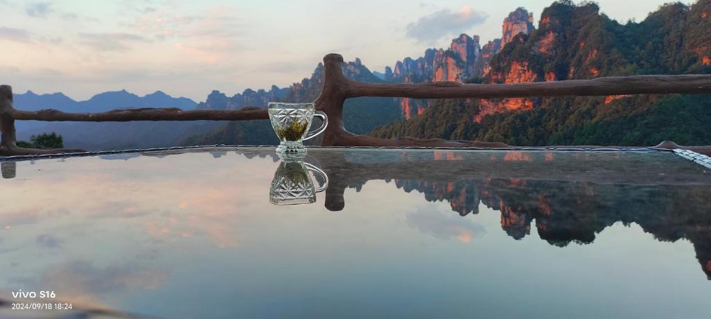 Eine Glasvase steht auf einem Wasserbecken. in der Unterkunft PeakMist Retreat Inside ZhangJiaJie Forest Park in Zhangjiajie