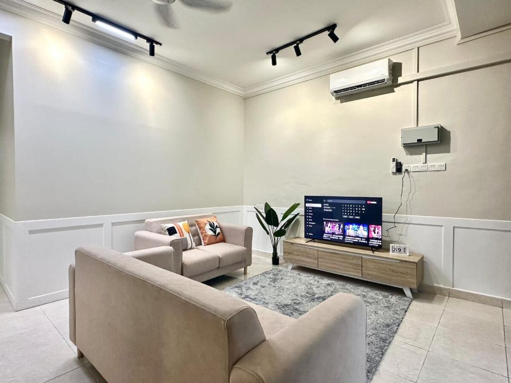 a living room with a couch and a tv at Vintage-Living 2Storey Haus12Pax in Simpang Ampat