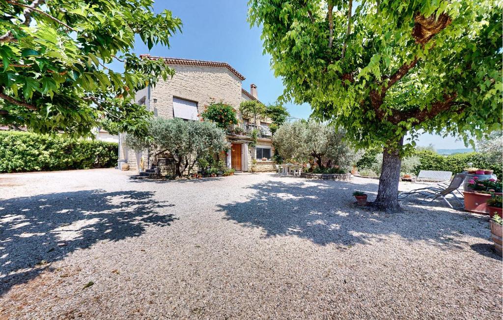 une maison avec un arbre et une allée de gravier dans l'établissement 2 Bedroom Gorgeous Apartment In Caromb, à Caromb