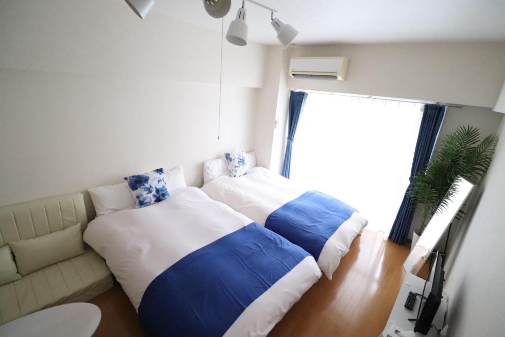 Un dormitorio con un sofá y dos almohadas grandes. en ロイヤルハイツ春日, en Kasugabaru