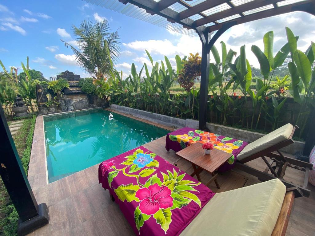 a backyard with a pool and a table and a table sidx sidx sidx at Shivananda Antique Villas by EPS in Ubud