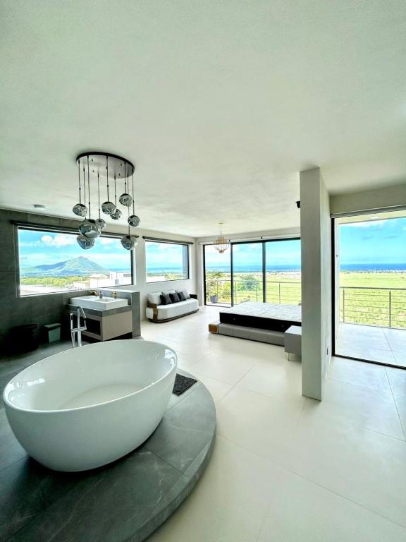 a bathroom with a large white tub in a room with windows at Luxury Villa with Ocean Views ! Minimum booking 1 week in Cascavelle