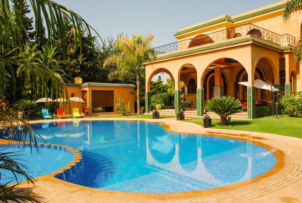 a swimming pool in front of a house at Riad Noumidya in F&egrave;s