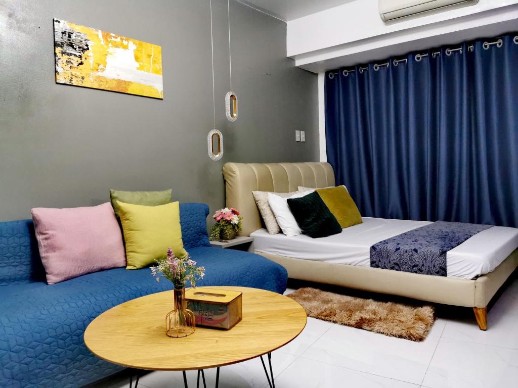 a room with a couch and a bed and a table at Elite Pod Manila in Manila