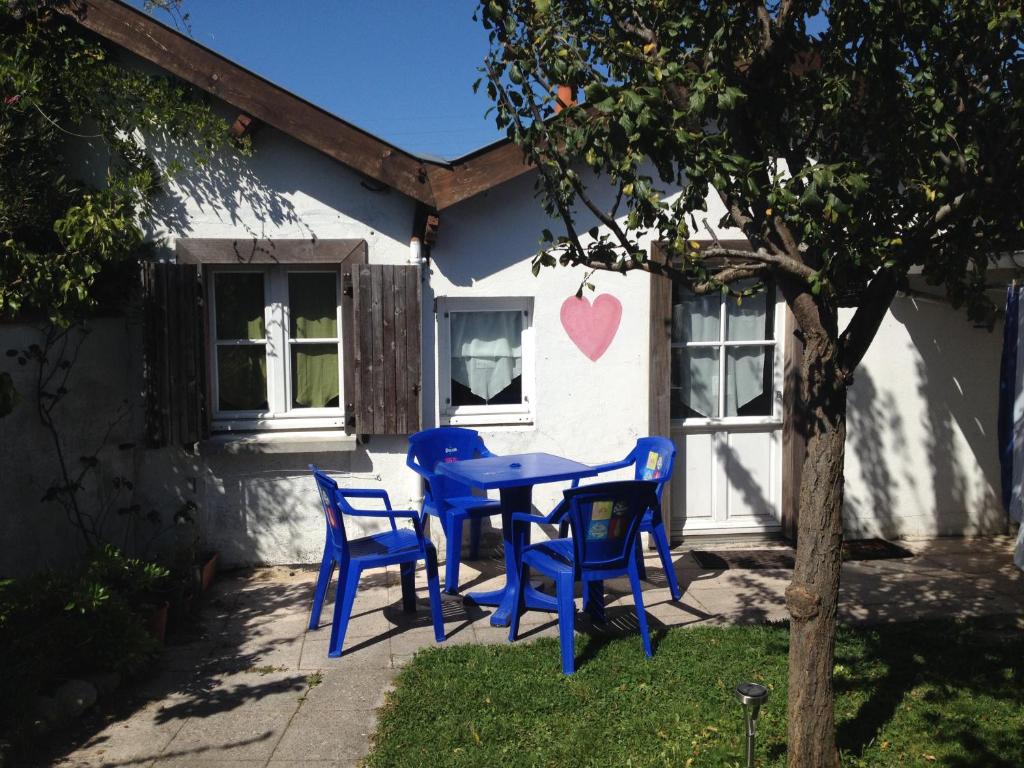 une table bleue et des chaises devant une maison dans l'établissement La Petite Maison de La Rochelle, à La Rochelle
