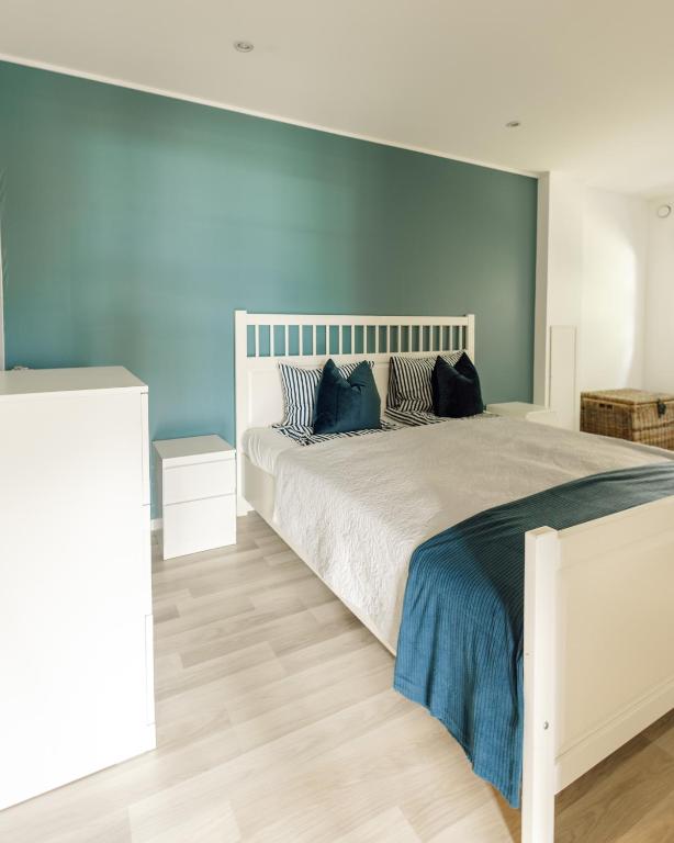 a bedroom with a large bed with a blue wall at Vestre apartment in Ålesund