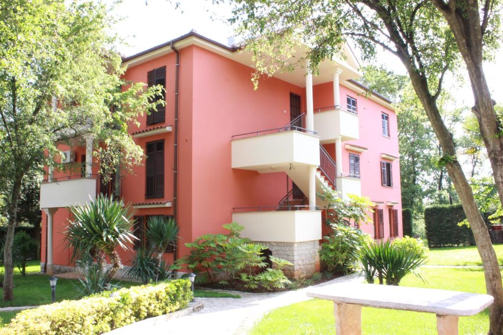 a pink building with a bench in front of it at Villa Plavo More in Novigrad Istria