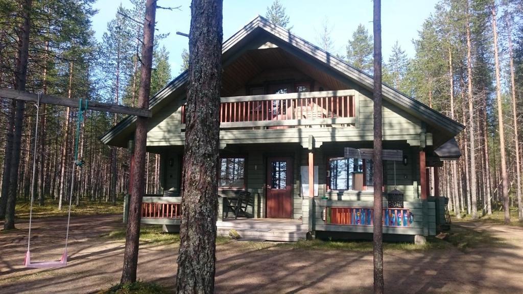 una cabaña de madera en el bosque con árboles en Vihreä Helmi en Kuusamo