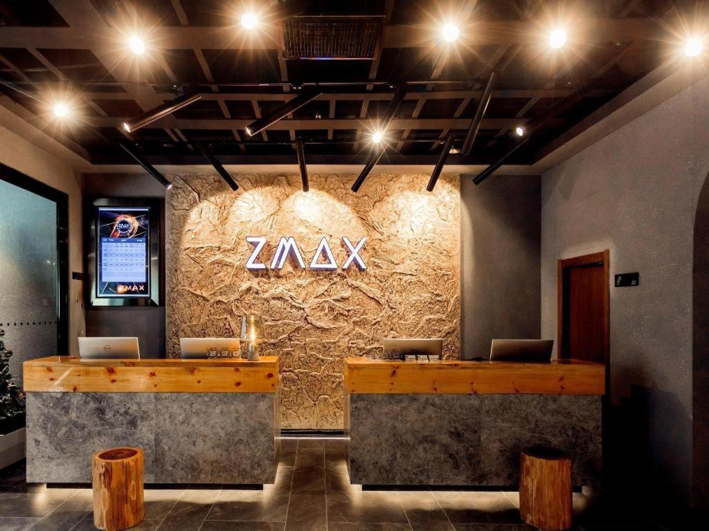 un hall avec un panneau sur un mur en pierre dans l'établissement ZMAX Hotel Yan'an Baimi Avenue Baotashan, à Qiao'ergou