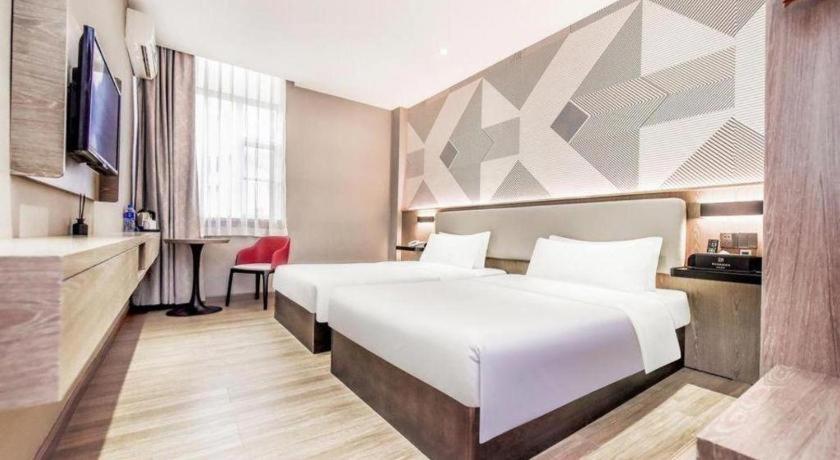 Postel nebo postele na pokoji v ubytování Borrman Hotel Zhuhai Mingzhu Railway Station Rainbow Shopping Mall