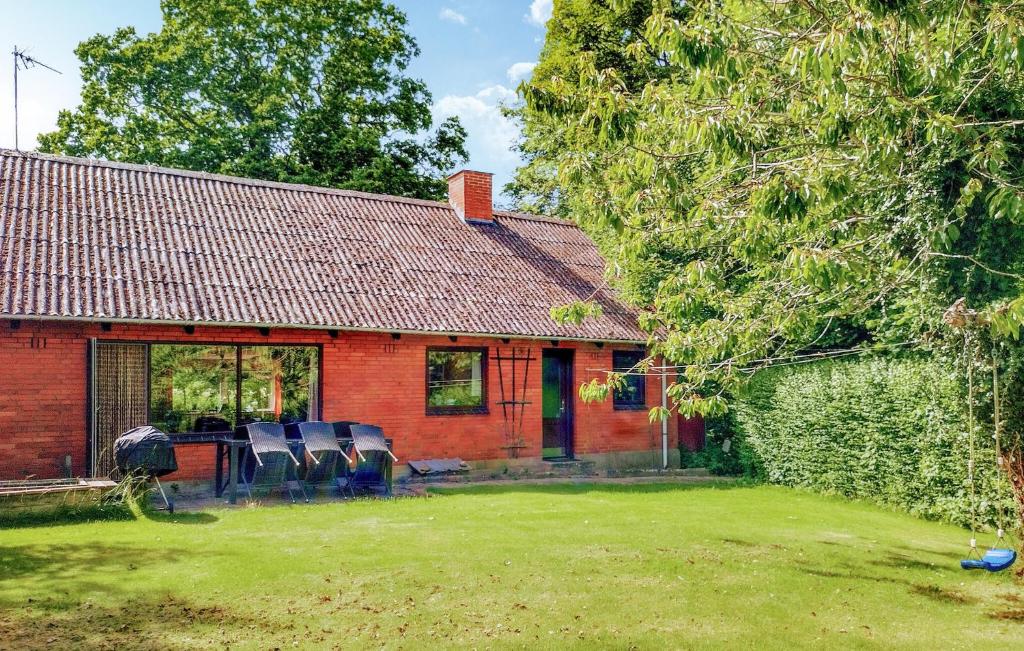 a red brick house with chairs in a yard at Holiday Home Stouby 07 in Stouby
