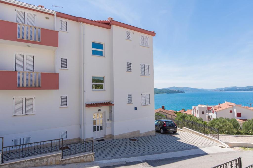 a large white building with a view of the water at Apartment Ljuba in Trogir