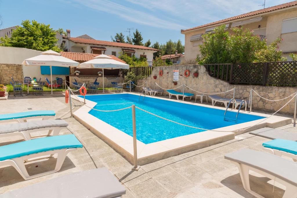 una piscina en un complejo con agua azul en Oscar en Kallithea Halkidikis
