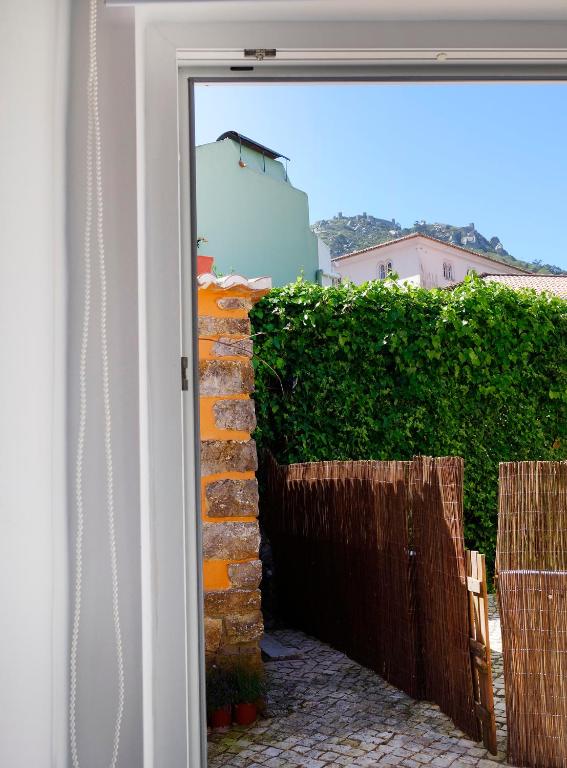 a door leading into a yard with a brick wall at Sparrow Sintra Nest in Sintra