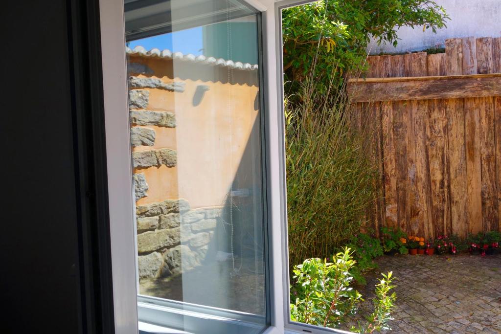 a sliding glass door to a garden with a fence at Sparrow Sintra Nest in Sintra