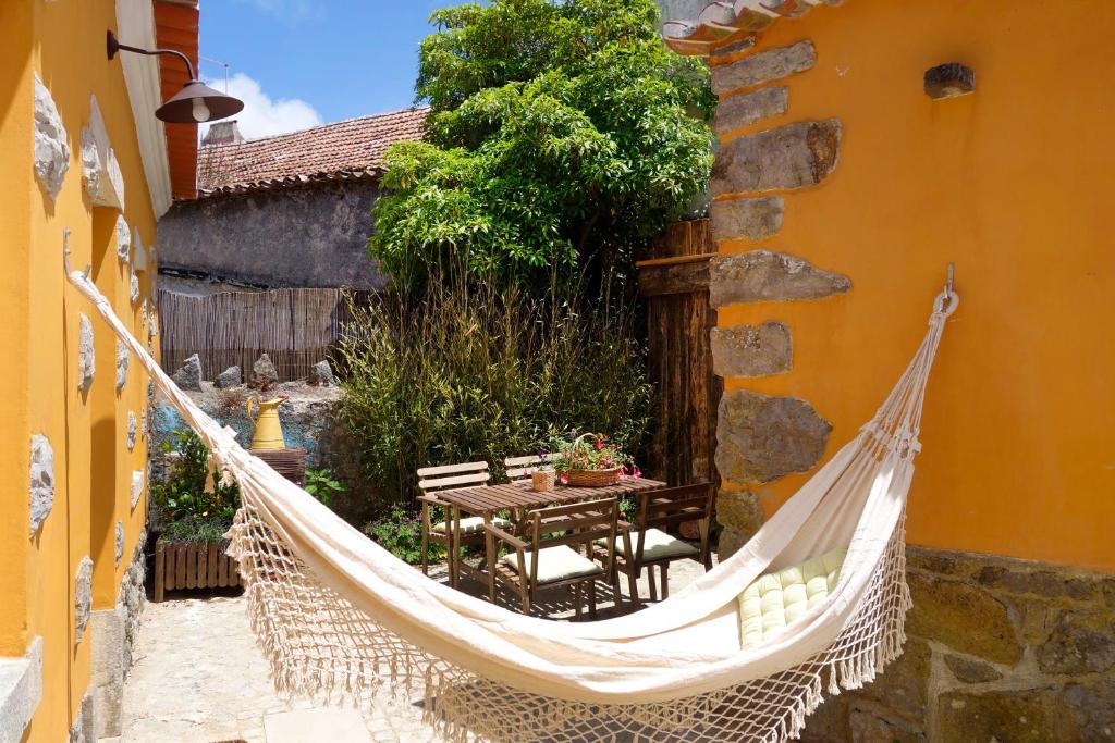 a hammock outside a building with a table and chairs at Sparrow Sintra Nest in Sintra