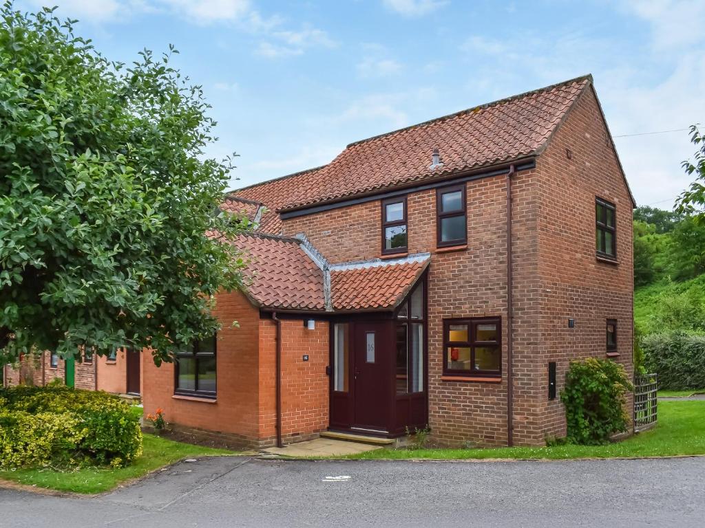 a red brick house with a red roof at Hey Ho Cottage in Whitby