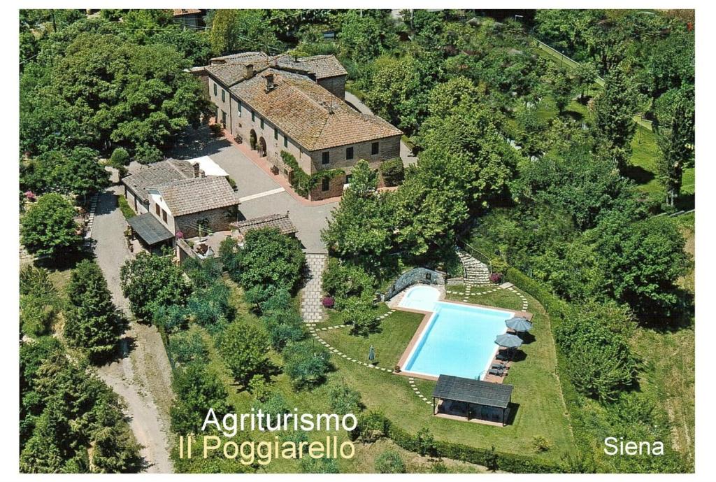 シエナにあるAgriturismo Il Poggiarelloのスイミングプール付きの家屋の空中ビュー