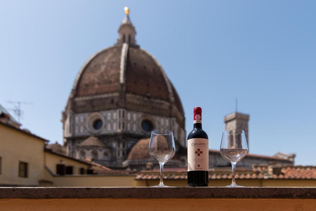 a bottle of wine and two glasses on a ledge at Era Rental Apartments in Florence
