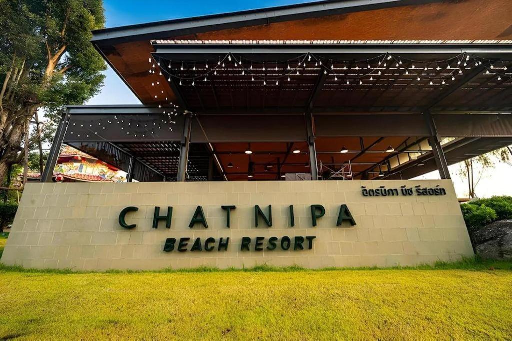 a sign for the chaminap beach resort in front of a building at Chatnipa Beach Resort in Rayong