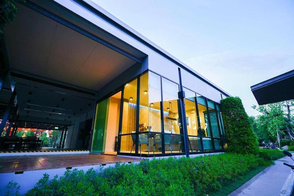 ein Gebäude mit großen Glasfenstern an der Seite in der Unterkunft Chatnipa Beach Resort in Klaeng