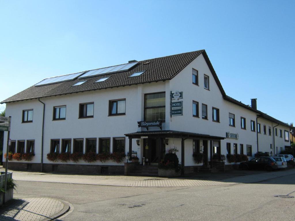 a large white building with windows on a street at Hotel Bürgerstube in Muggensturm