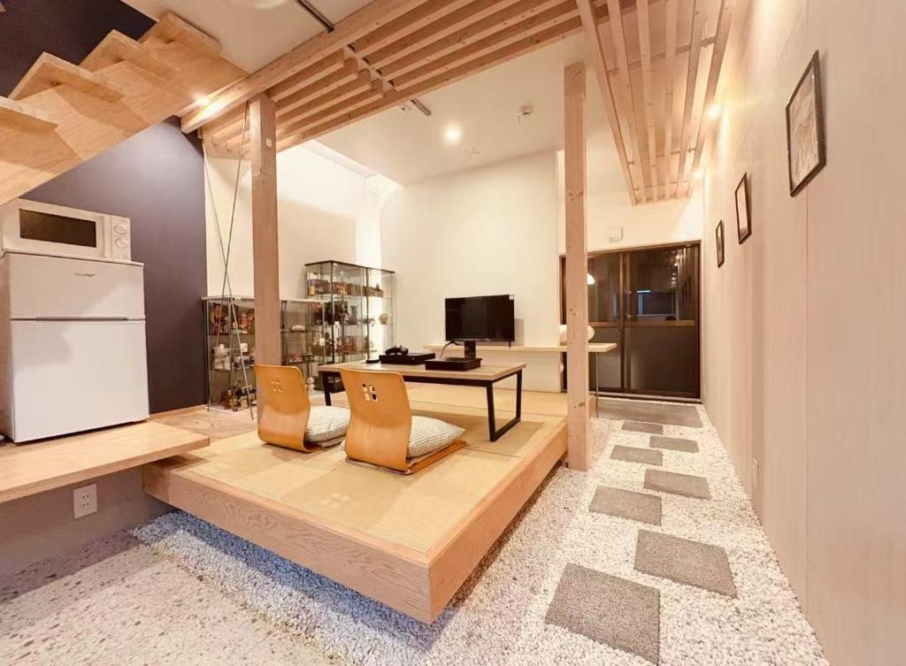 a living room with a table and chairs and a television at 東福寺2 都憶 in Kyoto