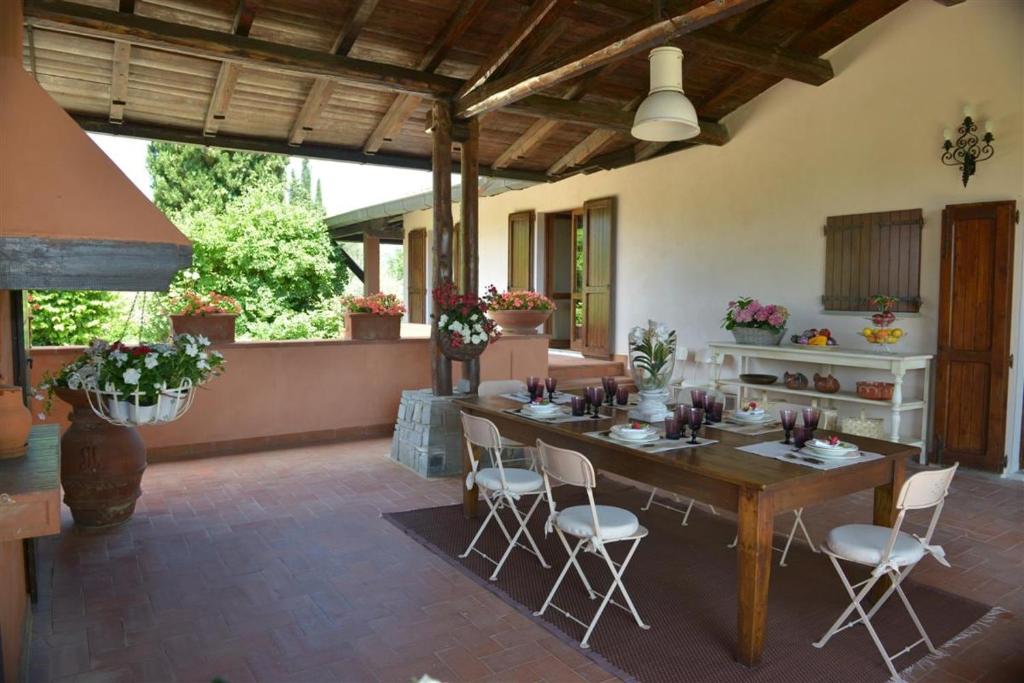 a large patio with a wooden table and chairs at Villa Ines with pool and Jacuzzi hot tube in Terranuova Bracciolini