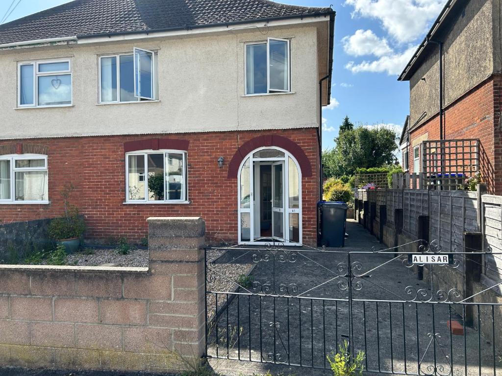 a red brick house with a black gate at The little flowers home in Salisbury
