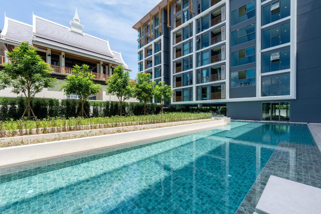 a swimming pool in front of a building at The Ozone Residences Bangtao Official Account in Bang Tao Beach