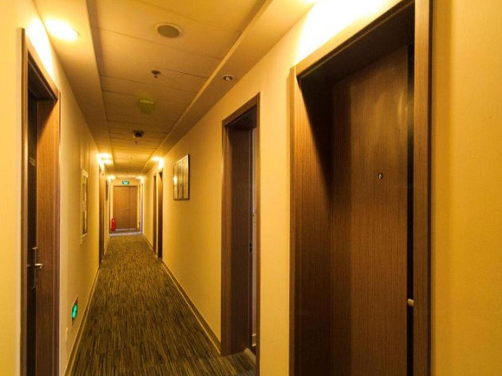 ein Flur mit gelben Wänden und einer Tür in der Unterkunft Jinjiang Inn Hangzhou Xihu Avenue Branch in Hangzhou