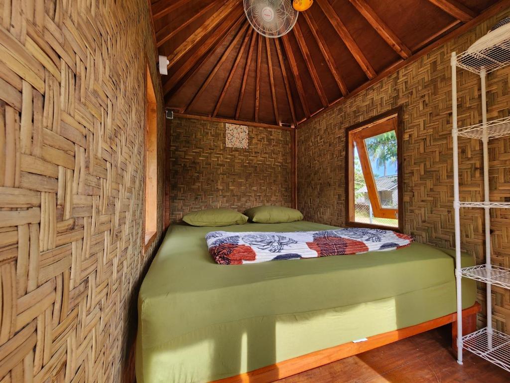 ein Schlafzimmer mit einem grünen Bett in einem Zimmer in der Unterkunft Mawun Valley Farmstays in Mangkung