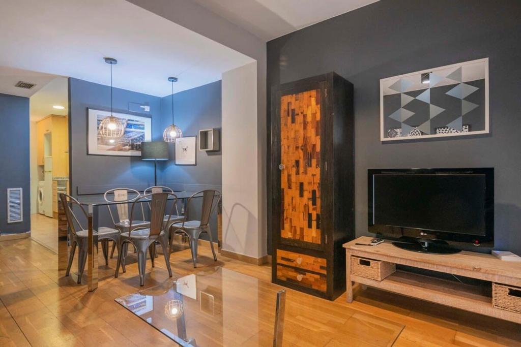 ein Wohnzimmer mit einem Esstisch und einem TV in der Unterkunft Bright and modern Duplex with terrace in Eixample district P2 in Barcelona