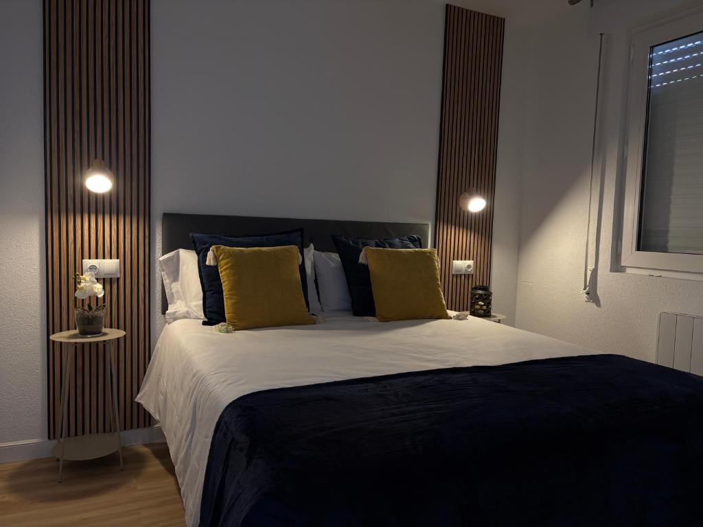 a bedroom with a large bed with blue and yellow pillows at Apartamento Cabo de Ajo in Ajo