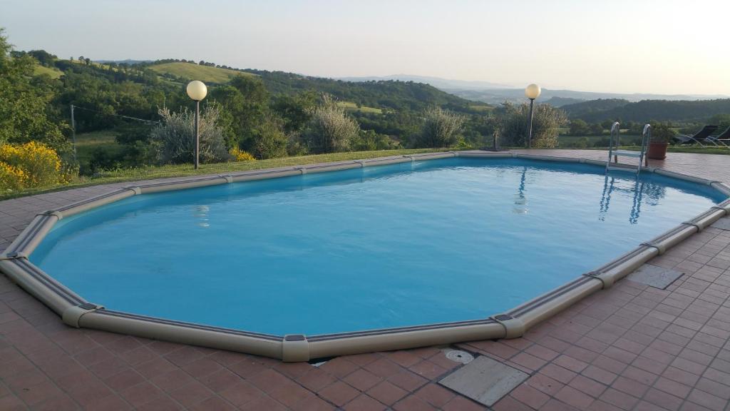 a large blue swimming pool on a tiled floor at Agriturismo La Meria in Semproniano